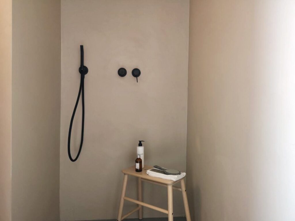 parete doccia neutra con rubinetteria nera