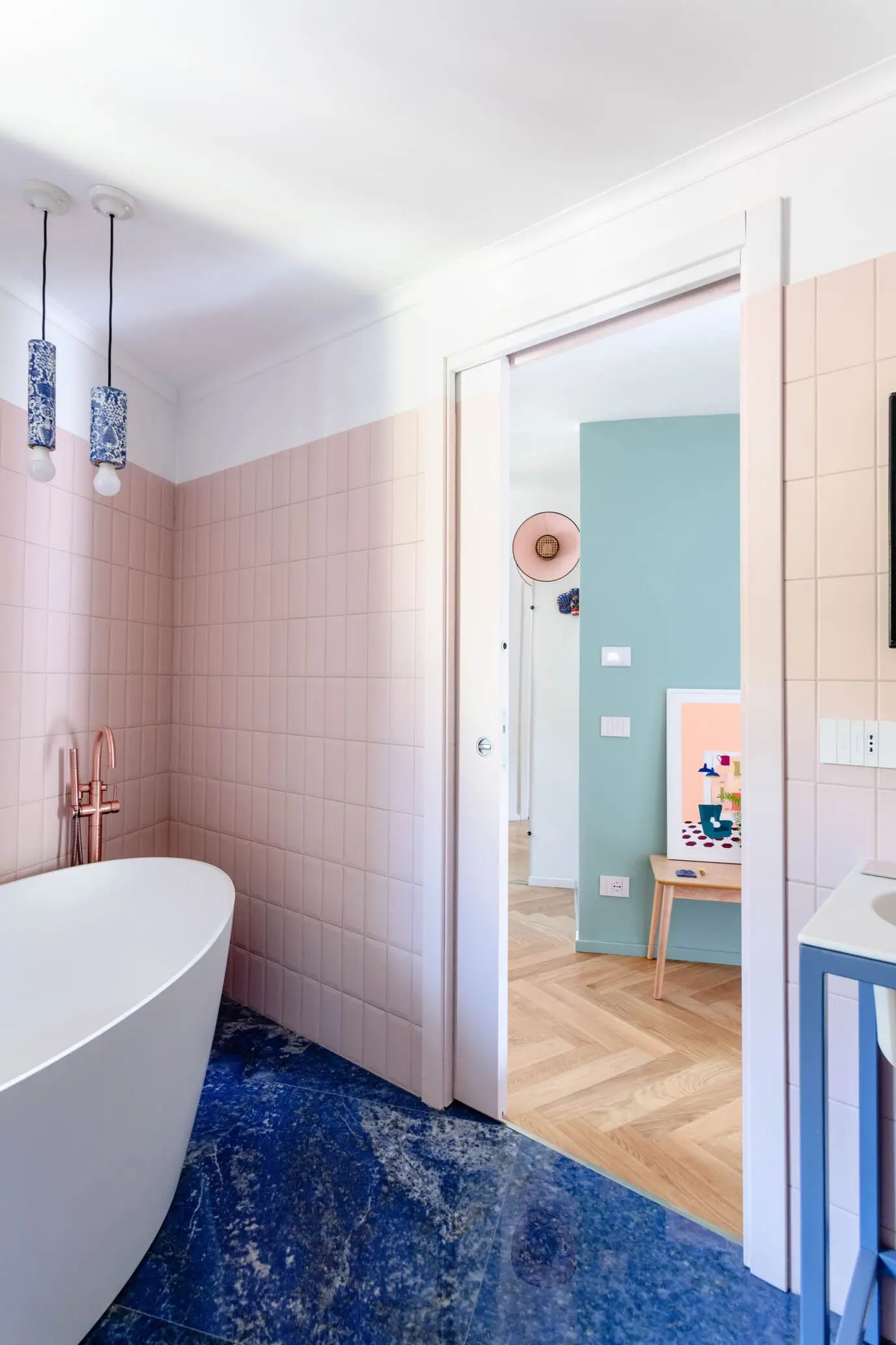 angolo vasca di bagno con piastrelle rosa e pavimento blu mare