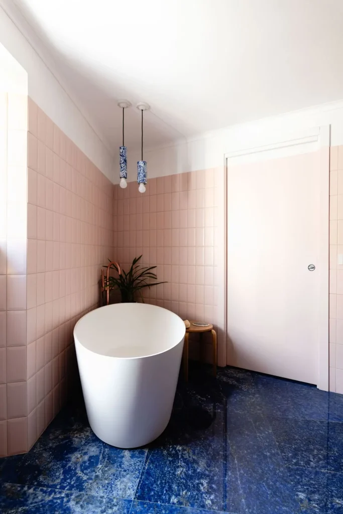 angolo relax con vasca freestanding, piastrelle bagno rosa e pavimento blu notte